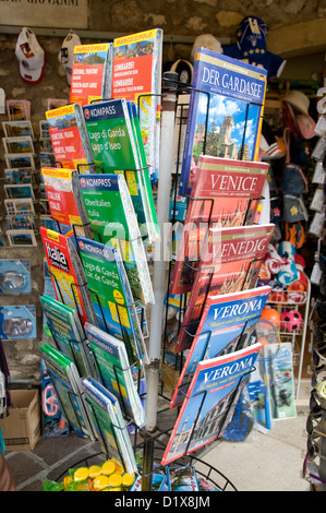 Un rack di mappe stradali italiane e guide turistiche Vendita in un piccolo paese di Garda sul Lago di Garda Nel Veneto, nel nord Italia Foto Stock