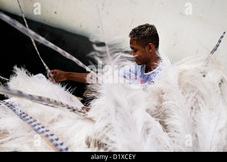 Un membro di una scuola di samba lavora sui costumi di carnevale (fantasias) all'interno del laboratorio a Rio de Janeiro in Brasile. Foto Stock