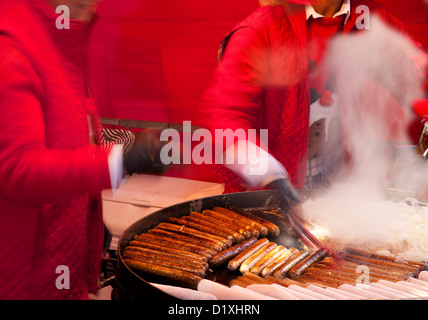 La vendita di prodotti alimentari e la frittura salsicce al Natale Fayre e festoso Dickensian festival in Skipton High Street, nello Yorkshire, Regno Unito Foto Stock