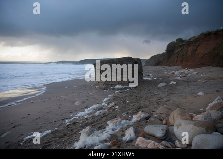 Erosione costiera a Hendra beach, Praa Sands in Cornwall Regno Unito ha lasciato questa seconda guerra mondiale porta pillole seduto sulla spiaggia Foto Stock