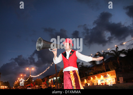 Clown su palafitte con un megafono in un festival. Fotografato in Israele a Kfar Yona Foto Stock