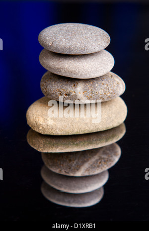 Pila di pietre equilibrata con ombre scure Foto Stock