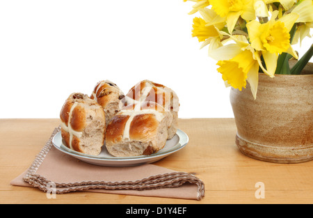 Pasqua tema, hot cross panini con daffodil fiori su un tavolo di legno Foto Stock