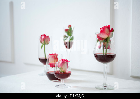 Vino rosso e fiori in bicchieri di vino Foto Stock