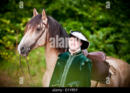 Frederiksborger. Rider in costume storico in piedi accanto a un stallone dun Foto Stock