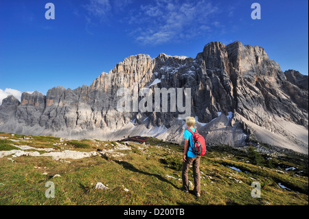 Donna che cammina verso il Rifugio Tissi, Civetta in background, Civetta e Dolomiti, Patrimonio Mondiale dell Unesco, Alto Adige, Ita Foto Stock