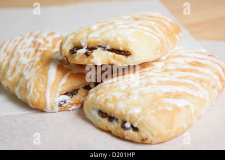 Tre iced croissant al cioccolato sulla carta oleata Foto Stock