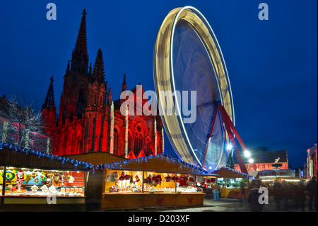 La Grande Ruota illuminata, mercato di Natale e storico quartiere, Tempio Saint-Etienne in background, Mulhouse, Alsazia, Francia Foto Stock