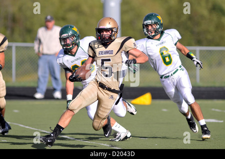 Giocatore di football fa un taglio durante un ritorno del kickoff cercando di rompere il gioco per big yardage durante una scuola di gioco. Stati Uniti d'America. Foto Stock