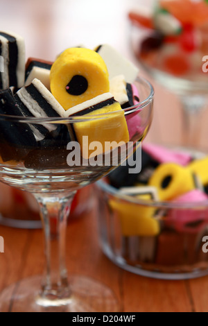 Una selezione di dolci in un bicchiere di champagne e vasi in vetro Foto Stock