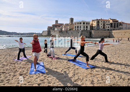 Persone che fanno lo yoga sulla spiaggia Plage de la Gravette, città vecchia di Antibes, Cote d'Azur, in Francia del Sud, Europa Foto Stock