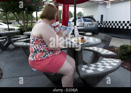 2 agosto 2012 - Marietta, GA - il sovrappeso di mezza età donna mangia ad alto tenore di grassi il pranzo di cheeseburger, amici e soft drink presso un ristorante fast food vicino ad Atlanta. (Credito Immagine: © Robin Nelson/ZUMAPRESS.com) Foto Stock