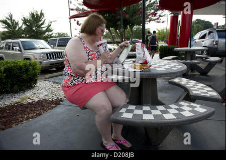 2 agosto 2012 - Marietta, GA - il sovrappeso di mezza età donna mangia ad alto tenore di grassi il pranzo di cheeseburger, amici e soft drink presso un ristorante fast food vicino ad Atlanta. (Credito Immagine: © Robin Nelson/ZUMAPRESS.com) Foto Stock