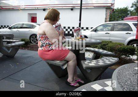 2 agosto 2012 - Marietta, GA - il sovrappeso di mezza età donna mangia ad alto tenore di grassi il pranzo di cheeseburger, amici e soft drink presso un ristorante fast food vicino ad Atlanta. (Credito Immagine: © Robin Nelson/ZUMAPRESS.com) Foto Stock