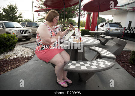 2 agosto 2012 - Marietta, GA - il sovrappeso di mezza età donna mangia ad alto tenore di grassi il pranzo di cheeseburger, amici e soft drink presso un ristorante fast food vicino ad Atlanta. (Credito Immagine: © Robin Nelson/ZUMAPRESS.com) Foto Stock