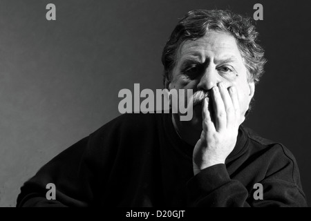 L uomo ha sollevato le sue mani per il suo volto Foto Stock