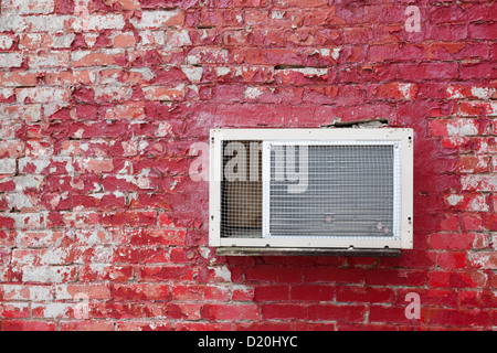 Vecchia unità di AC sul vecchio rosso un muro di mattoni. Foto Stock