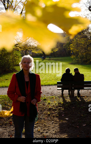 Titolare di pensione o di rendita godendo di una soleggiata giornata autunnale in un parco a Monaco di Baviera, Baviera, Baviera, Germania, Europa Foto Stock