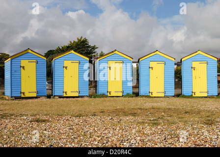 Il blu e il giallo dipinto di cabine sulla spiaggia, sul lungomare di Littlehampton. West Sussex. Inghilterra Foto Stock