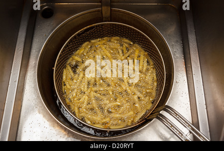 Patate fritte a caldo in una friggitrice a snack bar Foto Stock