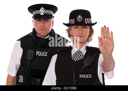 Studio shot di maschio e femmina British ufficiali della polizia in uniforme di indossare giubbotti antiproiettile. Il WPC è fermata di segnalazione. Foto Stock