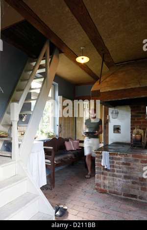 Uomo che porta una teglia da forno in cucina, Klein Thurow, Roggendorf, Meclemburgo-Pomerania, Germania Foto Stock