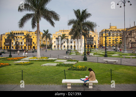 La donna si siede su una panchina nel parco a Plaza de Armas, Lima, Perù, Sud America Foto Stock