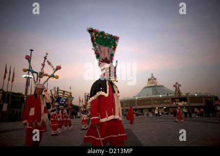 Un pellegrino vestito come un diavolo rosso esegue il baile de los Santiagos o Saint James's Dance al di fuori della Nostra Signora di Guadalupe Foto Stock