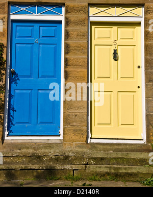 Coppia di porte di casa affiancati uno blu uno giallo Foto Stock