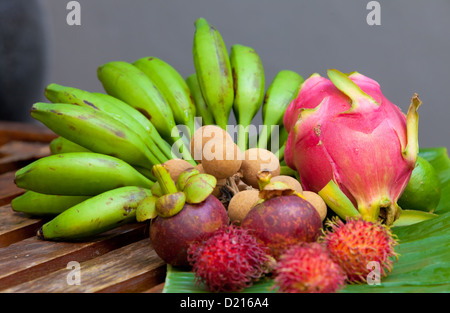 Visualizzazione della frutta tropicale su foglia di banana sul tavolo di legno nella luce naturale Foto Stock