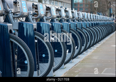 Boris o Barclays biciclette a noleggio in un rack sul percorso del Tamigi a Londra REGNO UNITO con prospettiva compressa Foto Stock