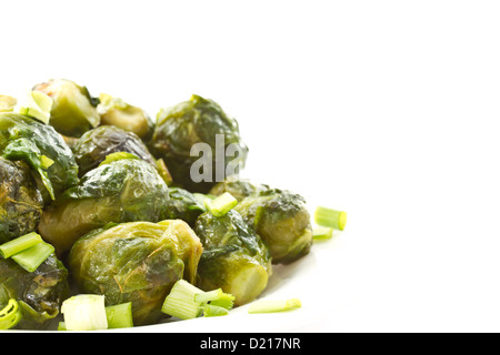 Arrosto di cavolini di Bruxelles su sfondo bianco Foto Stock