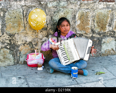 Bella giovani indigeni messicani ragazza indiana seduta sul marciapiede con palloncino a suonare la fisarmonica per dispense Oaxaca Messico Foto Stock