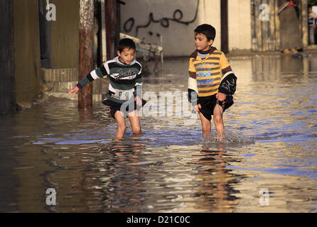 Gen. 10, 2013 - Gaza City, nella Striscia di Gaza, Territori palestinesi - i bambini palestinesi a piedi in una strada allagata dopo piogge torrenziali. (Credito Immagine: © Sameh Rahmi APA/images/ZUMAPRESS.com) Foto Stock