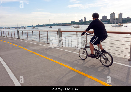 Uomo in sella ad una bicicletta pieghevole in Riverside Park Foto Stock