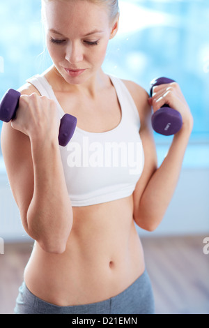 Ritratto di forte sollevamento ragazza barbells in palestra Foto Stock