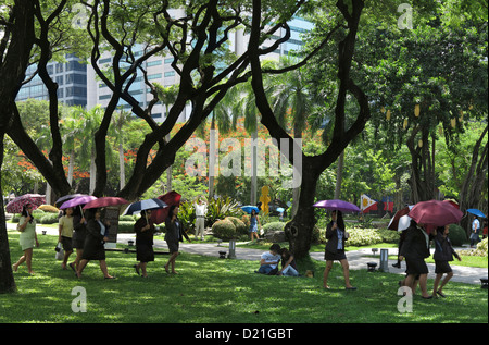 Le donne con ombrelloni, Ayala Triangle Park in Makati City, isola di Luzon, Filippine, Asia Foto Stock