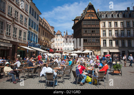 Persone a outdoor cafe con ristorante Maison Kammerzell in background in piazza della cattedrale di Strasburgo, Alsazia, Francia Foto Stock