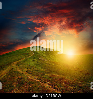 Tramonti sulle montagne di rosso le nuvole Foto Stock