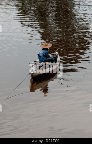 Singolo pescatore in una barca sul fiume di Kuching, Sarawak, Malaysia Foto Stock