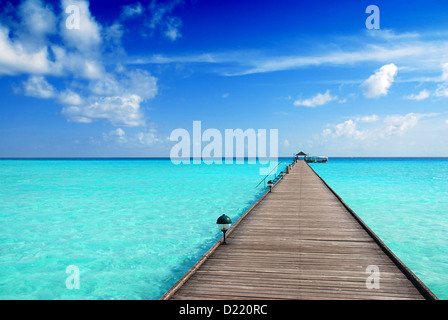 Pontile in legno sul bellissimo mare maldiviano con cielo blu Foto Stock