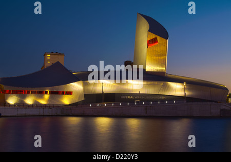 Imperial War Museum North al crepuscolo, attraverso il Manchester Ship Canal Foto Stock