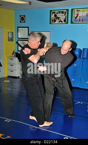 Hapkido cintura nera combattenti praticare la loro arte in una scuola di arti marziali. Foto Stock