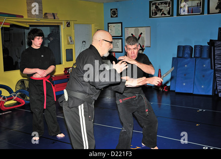 Hapkido cintura nera combattenti praticare la loro arte in una scuola di arti marziali. Foto Stock