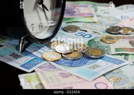 Il tempo è denaro concetto con il polacco delle monete e delle banconote in euro Foto Stock