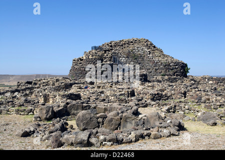 Sardegna: nuraghe Su Nuraxi - Vista del bastione quadrilobate con i resti del villaggio nuragico in primo piano Foto Stock