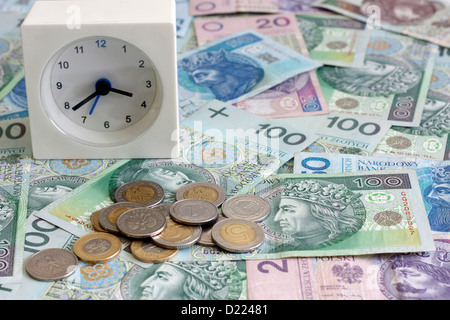 Il tempo è denaro concetto con il polacco delle monete e delle banconote in euro Foto Stock