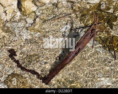 Vecchio arrugginito elemento di ancoraggio sulla costa rocciosa Foto Stock