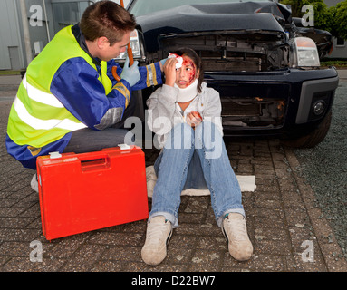 Paramedico che si prendono cura di una donna malata dopo un incidente di automobile Foto Stock