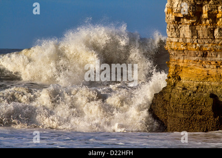 Le onde rompono contro Marsden Rock in mare mosso, Marsden Bay, South Shields, Inghilterra Foto Stock
